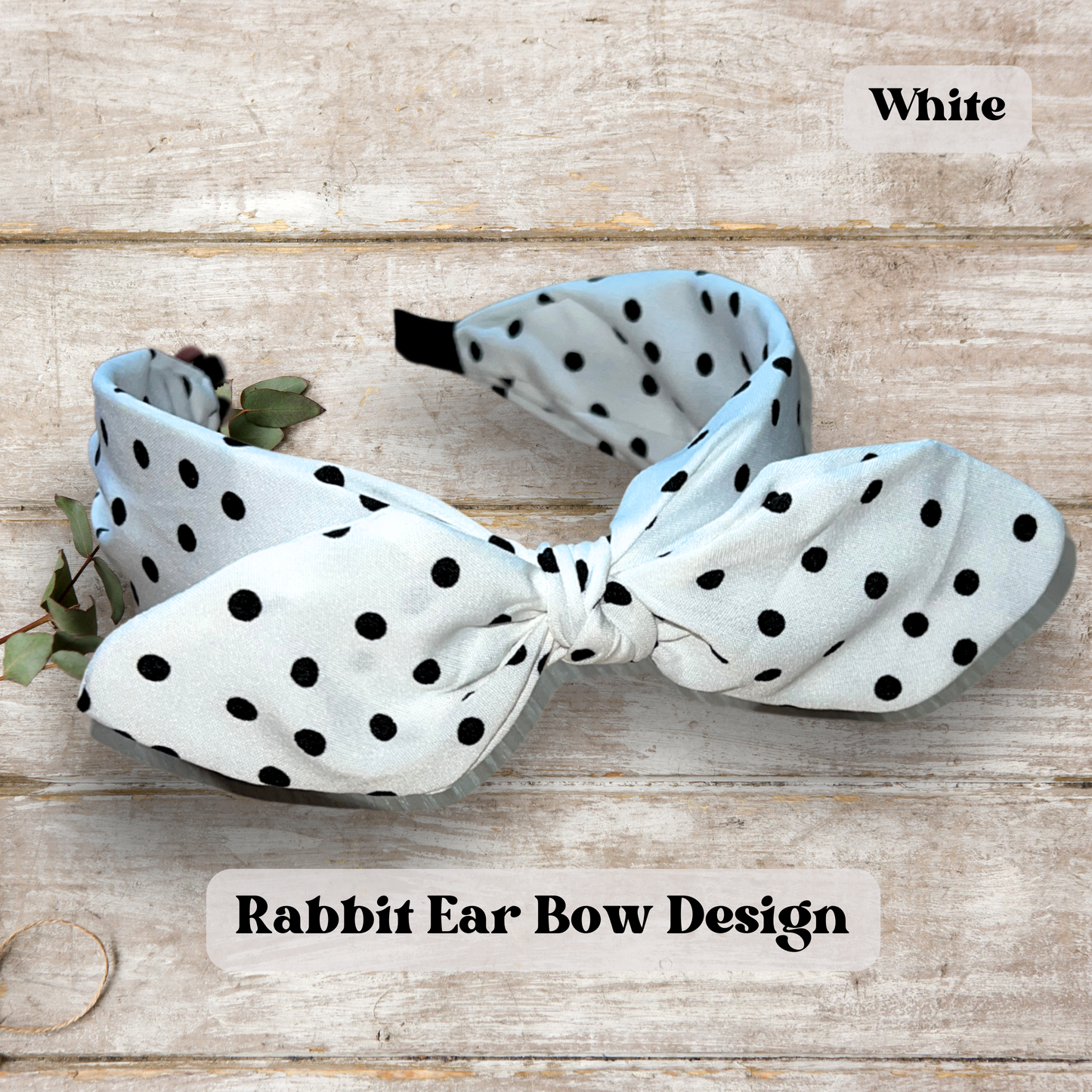 White rabbit ear headband on light wood table.