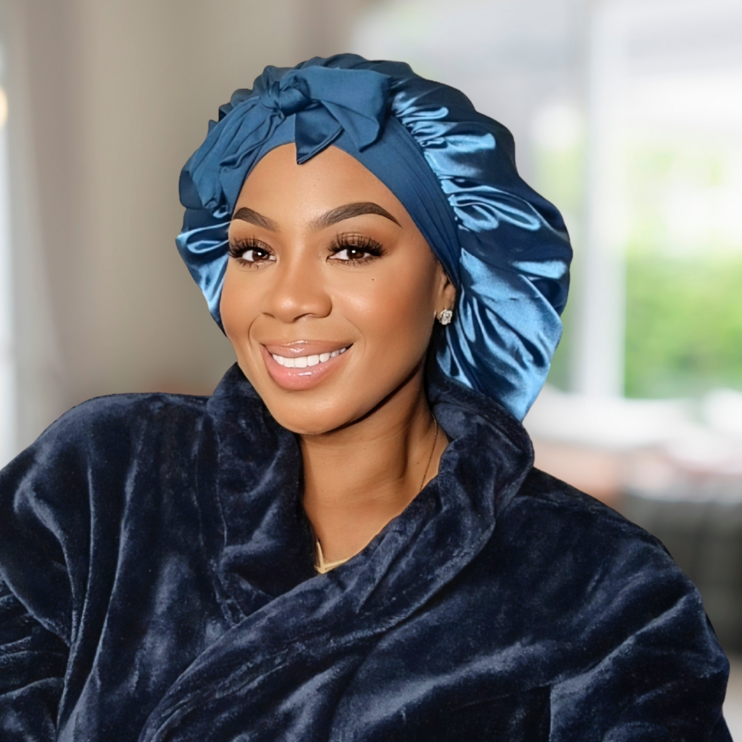 Main image of a Model wearing a Peacock blue Stretch Tie satin hair bonnet tied in a bow. The bonnet is showcasing a smooth satin texture and vibrant color. Ideal for curly, natural, and protective hairstyles.
