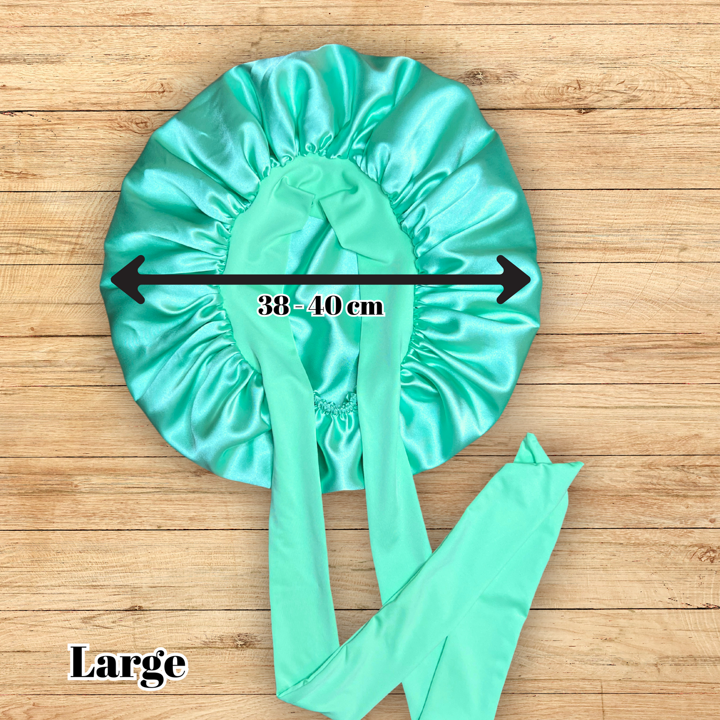 Large size Aqua green stretch tie bonnet on wooden table.