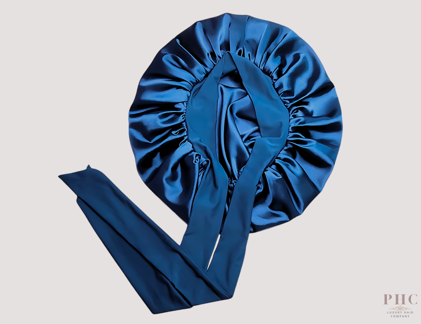 midnight blue satin hair bonnet on a gray background