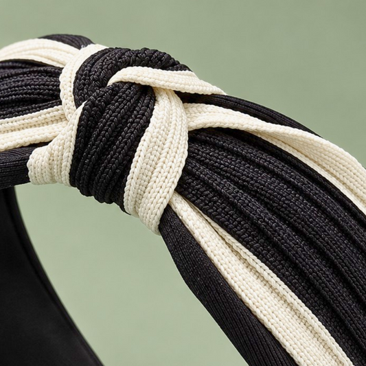 Close-up of the black and cream braided fabric and center knot on a two-tone twisted headband.