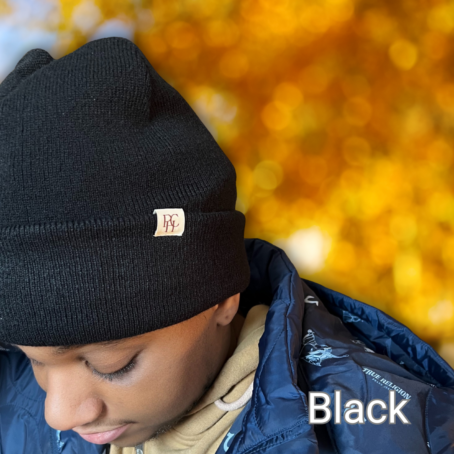 African American Male modeling a Prince Hair Company Satin Lined Beanie in Black on a blurred out fall background.