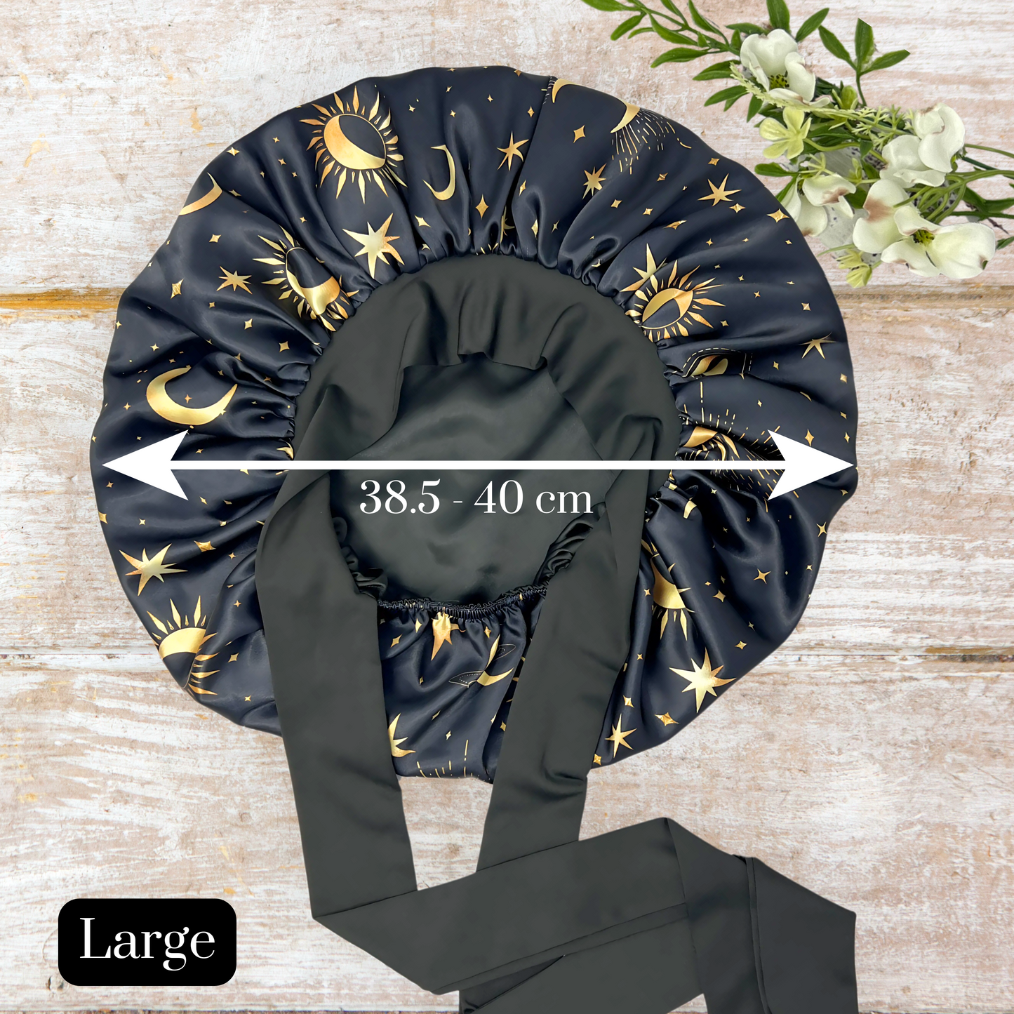 Satin Lined Bonnet in Custom PHC Starry Print with adjustable stretch ties in large on a wooden background. Perfect silky satin sleep cap for protecting your hair throughout the night.