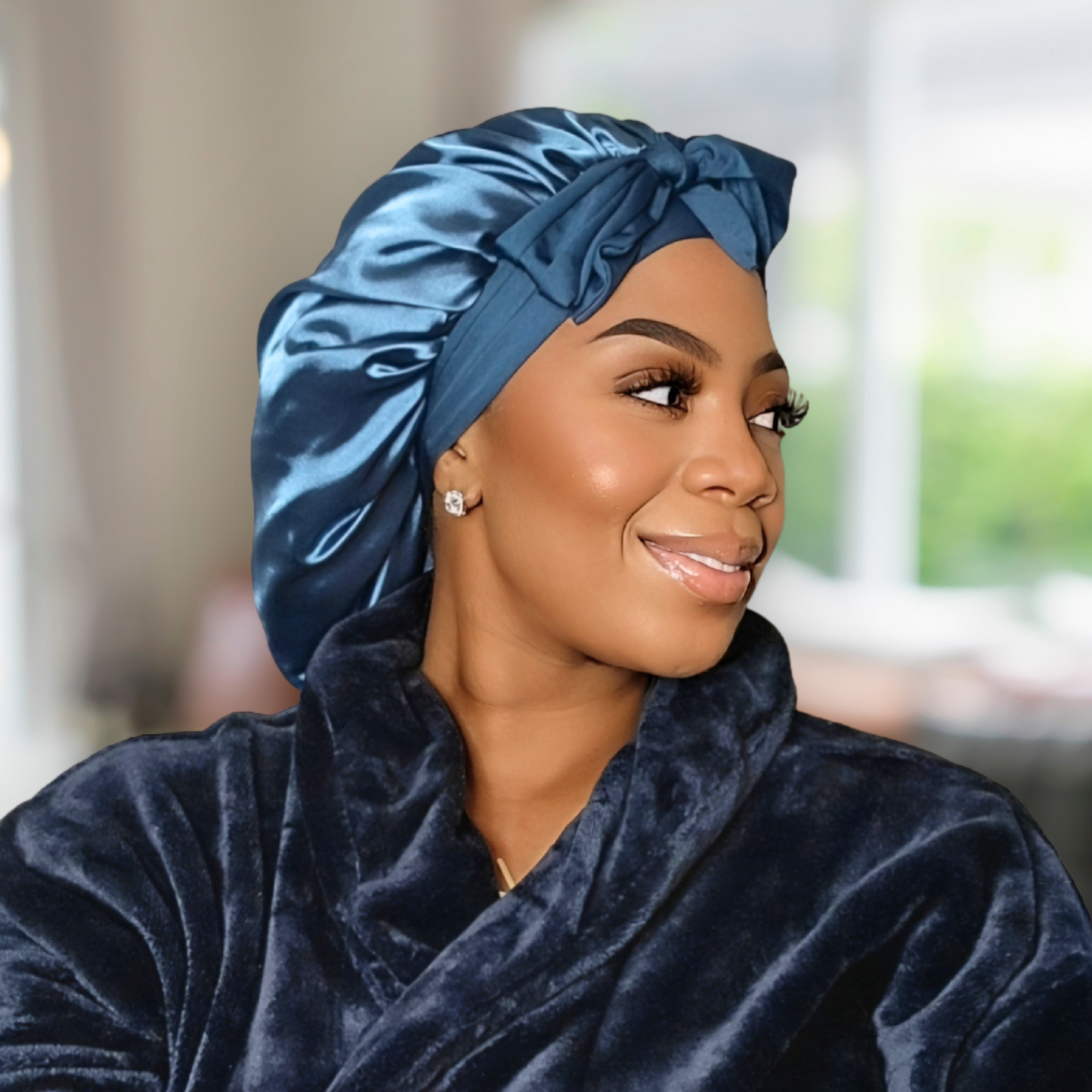 Model wearing a Peacock blue Stretch Tie satin hair bonnet tied in a bow. The bonnet is showcasing a smooth satin texture and vibrant color. Ideal for curly, natural, and protective hairstyles.