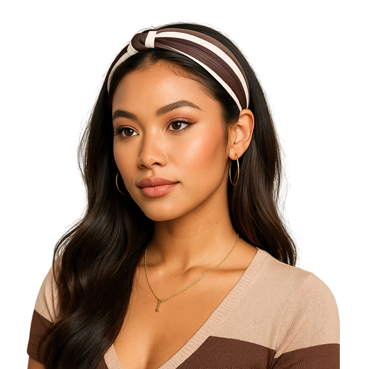 Woman wearing a minimalistic vintage inspired brown and cream colored headband with a beige sweater on a white background