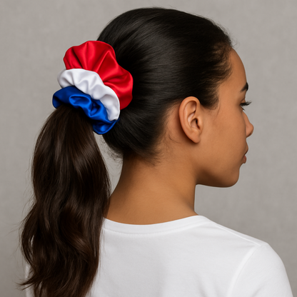 Mixed-race woman with long hair wearing red, white, and blue satin scrunchies in a high ponytail, styled for 4th of July.
