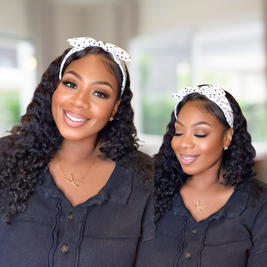 Beautiful model in a blurred background  wearing a white and black polka dot rabbit ear headband over her long curly hair.