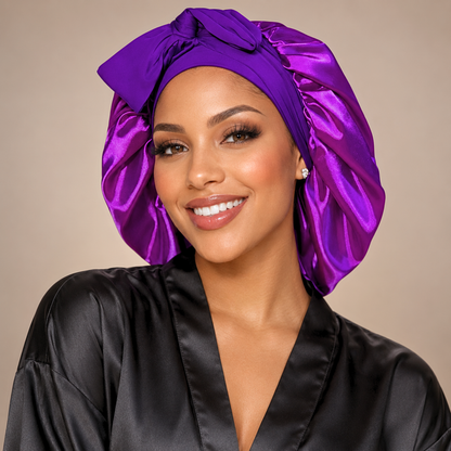 Large purple satin bonnet with matching stretch-tie bow in a studio portrait