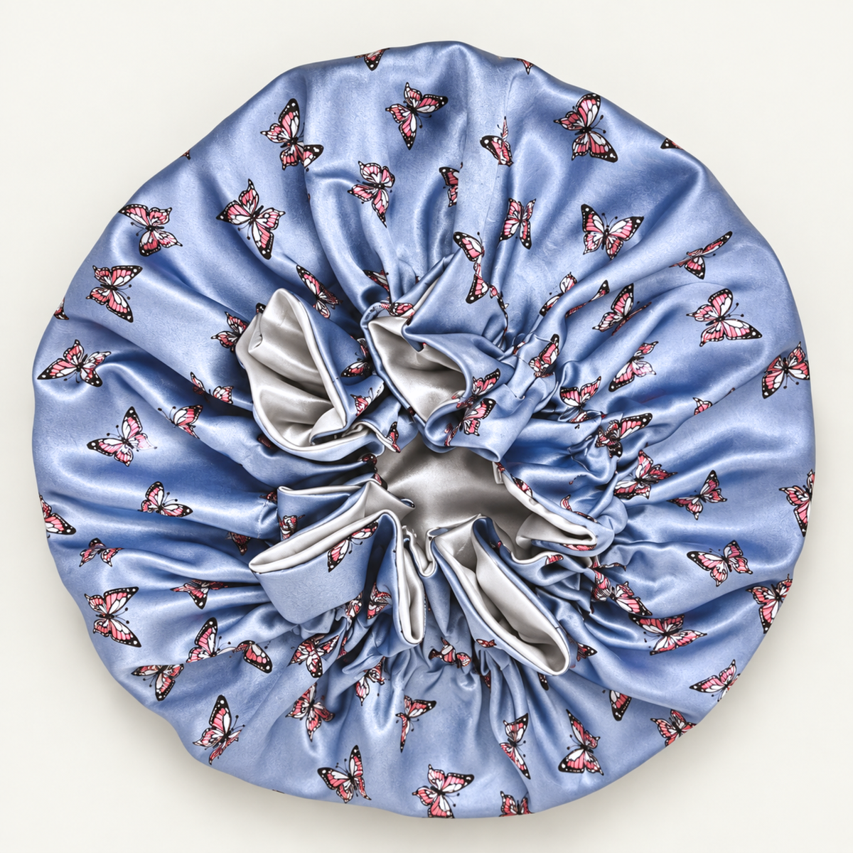 Pewter Butterflies ruffle satin bonnet laid flat, dusty blue butterfly print with silver bow