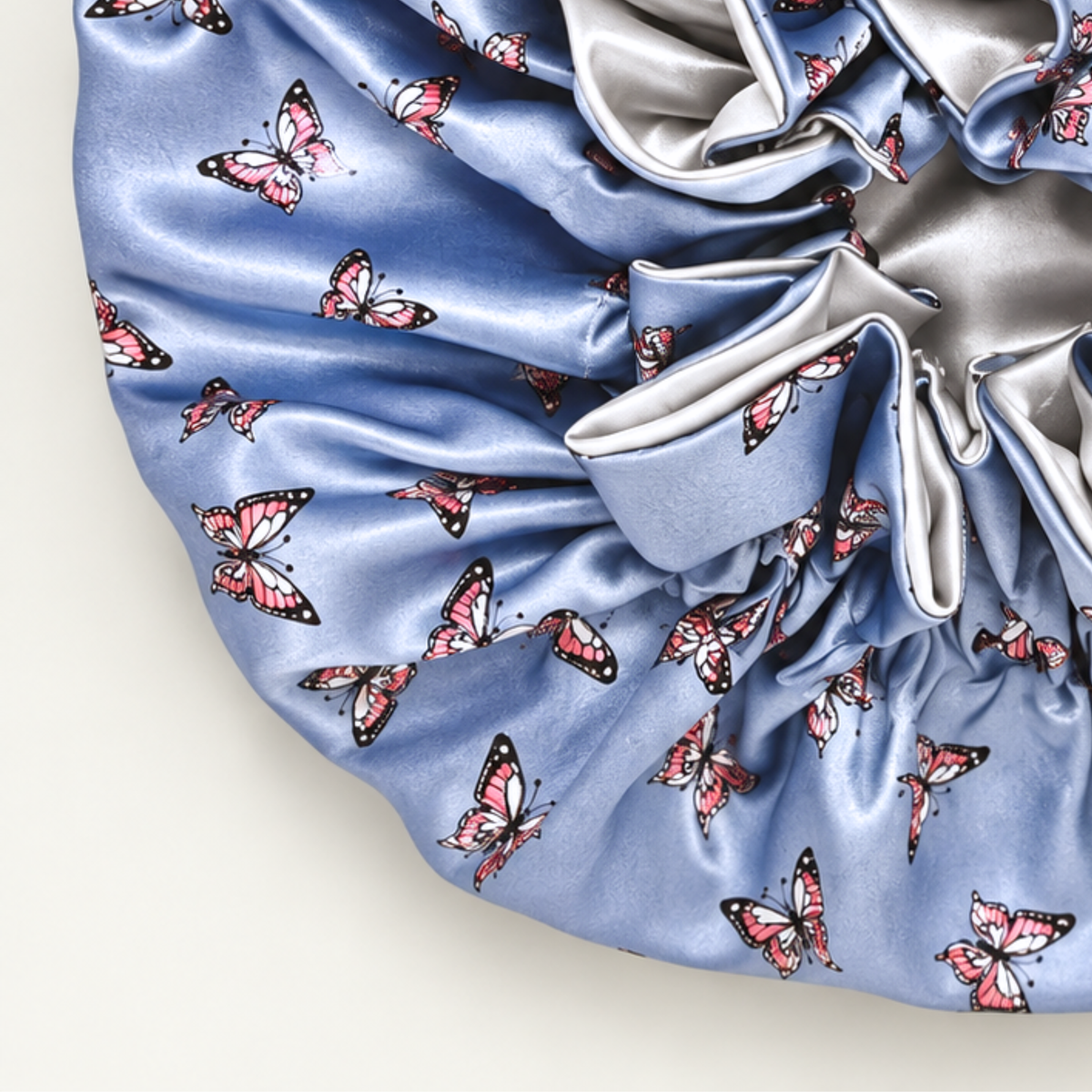 Close-up of the Pewter Butterflies ruffle satin bonnet showing the silver satin side