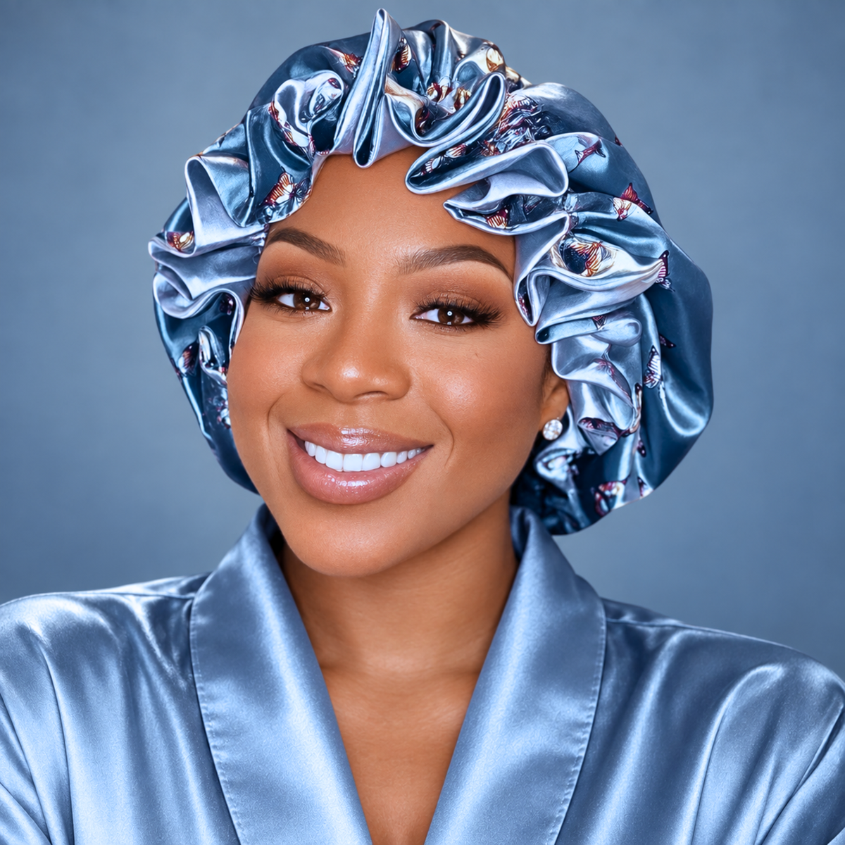 Woman wearing the Pewter Butterflies ruffle satin bonnet, dusty blue with butterfly print
