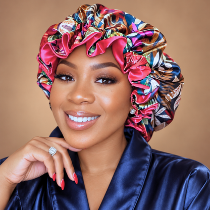 Woman wearing the Pink Autumn ruffle satin bonnet, dark leaf print with gold and pink