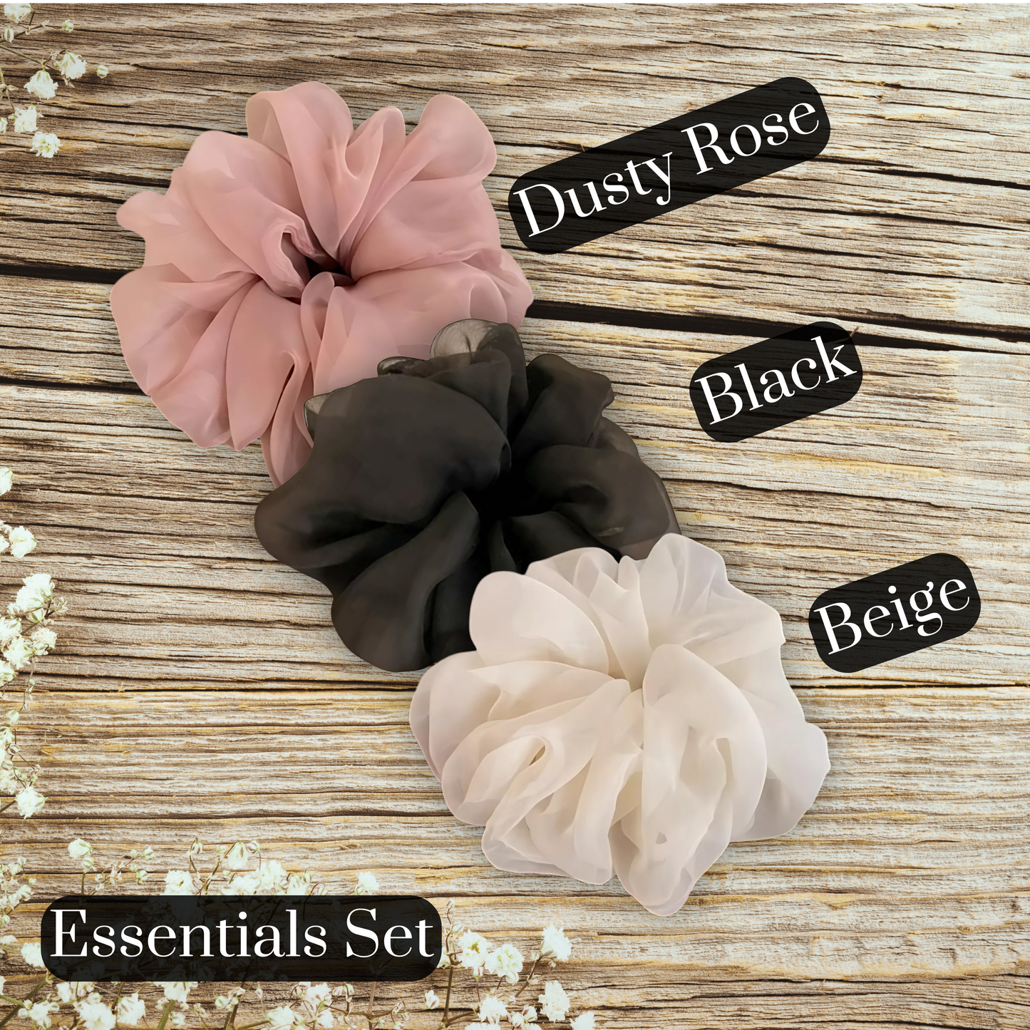 Oversized chiffon scrunchies in black, pink, and beige displayed on a wooden table, perfect for elegant hairstyles and versatile hair accessories.