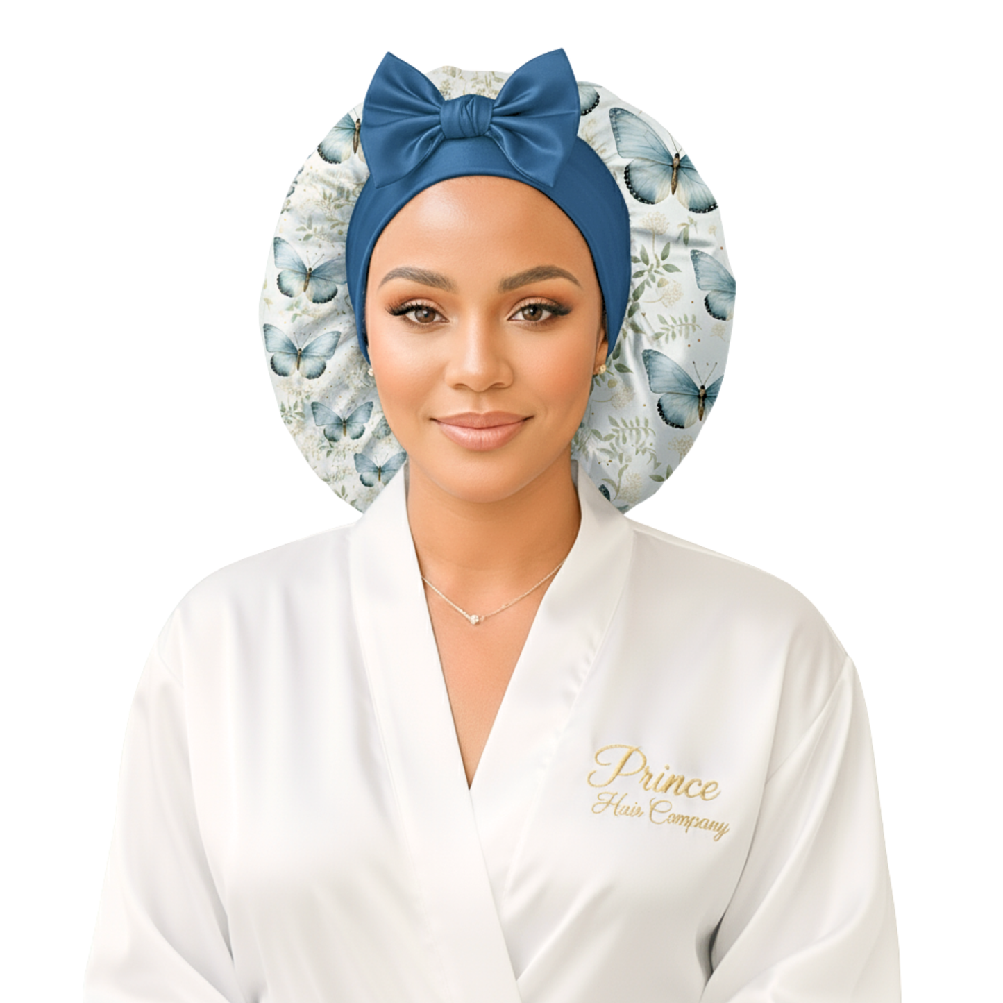 A woman wearing a butterfly floral-patterned charmeuse satin silk hair bonnet with long stretch ties formed into a bow. She is in a softly lit indoor setting with a blurred background, highlighting the bonnet’s elegant shine and handmade quality. This luxury satin sleep cap protects natural, curly, and textured hair while maintaining a cute, comfortable fit.