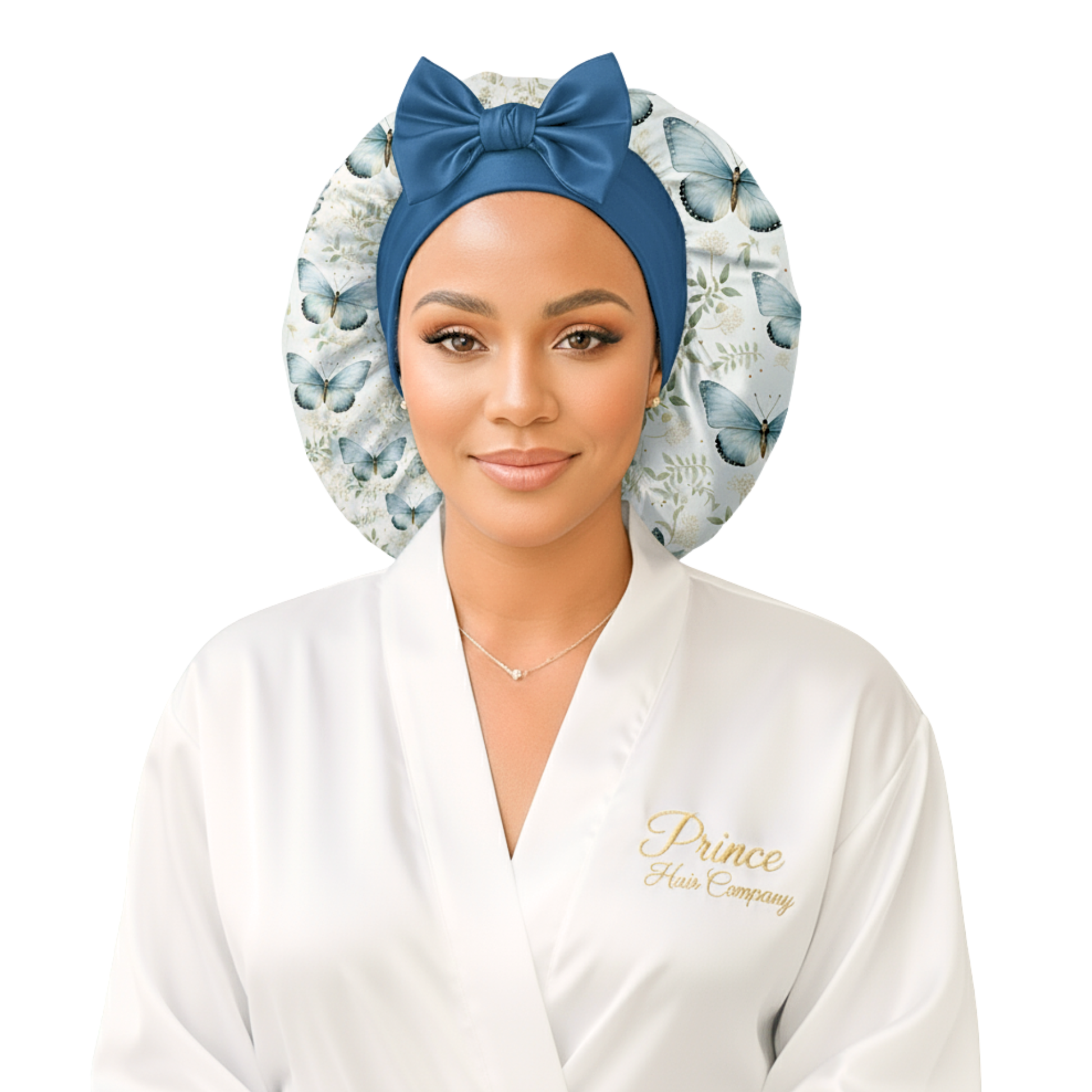 A woman wearing a butterfly floral-patterned charmeuse satin silk hair bonnet with long stretch ties formed into a bow. She is in a softly lit indoor setting with a blurred background, highlighting the bonnet’s elegant shine and handmade quality. This luxury satin sleep cap protects natural, curly, and textured hair while maintaining a cute, comfortable fit.