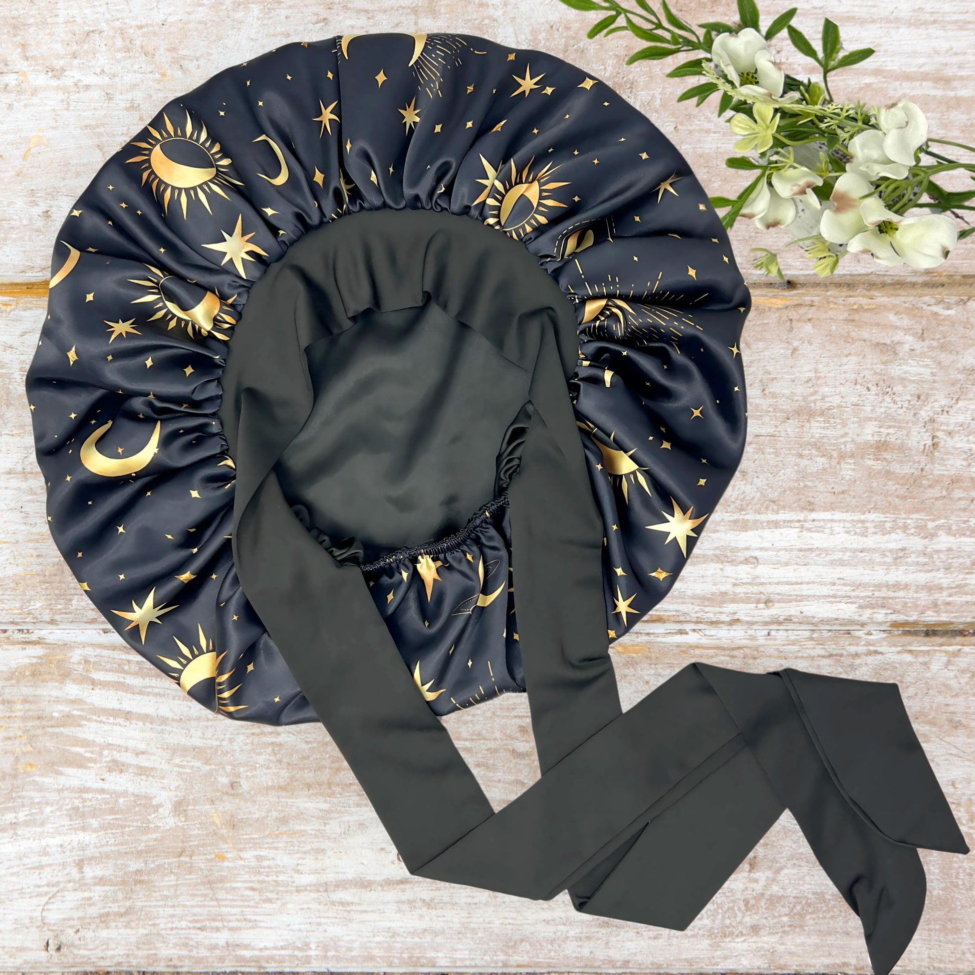 Handmade Charmeuse Silk Satin Sleep Bonnet in a Celestial Starry Night Cosmic Print with adjustable stretch ties. Features a double-layer satin design that protects hair from frizz and breakage while locking in moisture. Unisex silk bonnet made in the USA by Prince Hair Company.