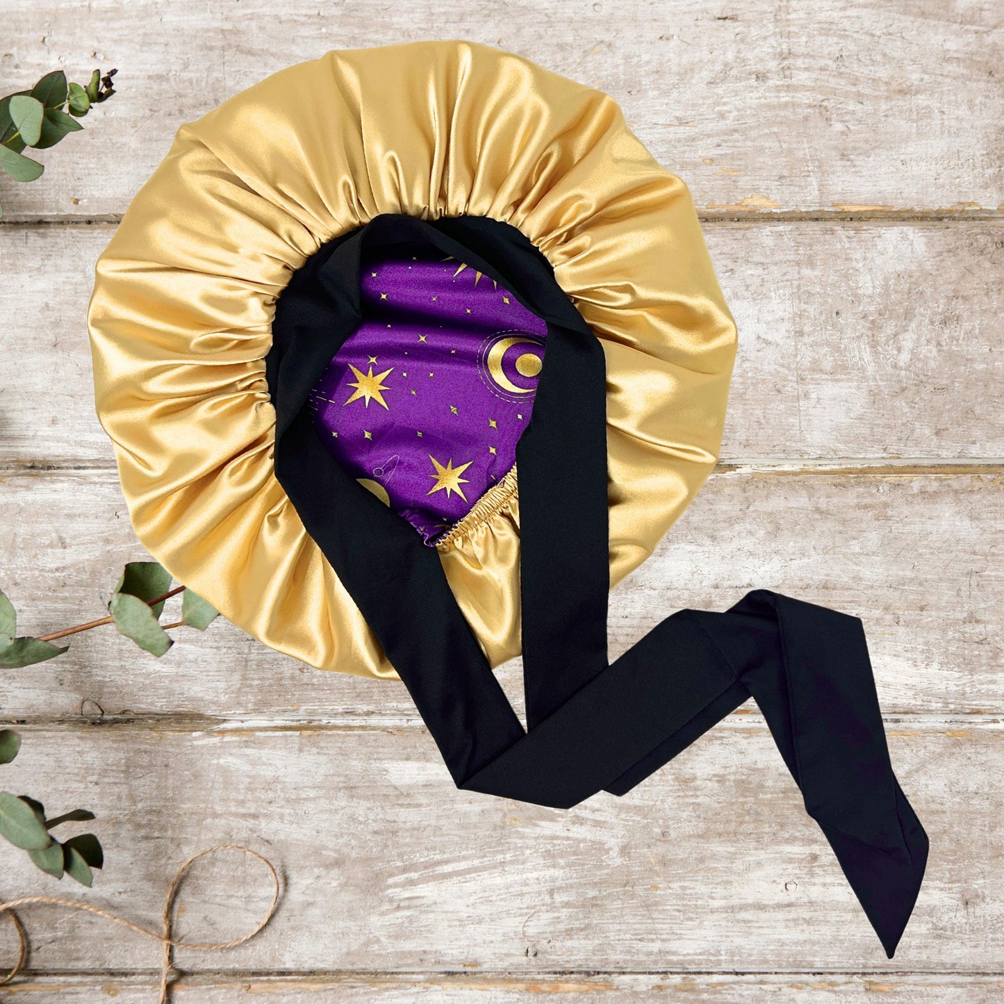 Interior view of the Celestial Plum bonnet highlighting the high-quality gold satin lining and black stretch tie.