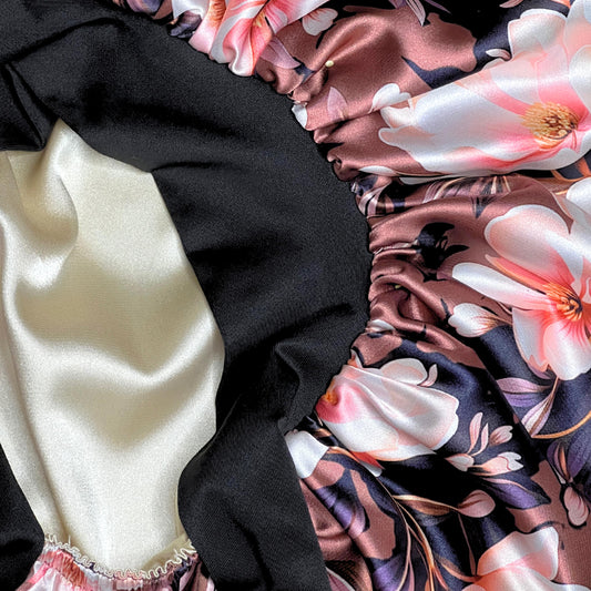Close up detail of the brown magnolia satin bonnet showing the floral print, stretch tie band, and champagne satin lining.