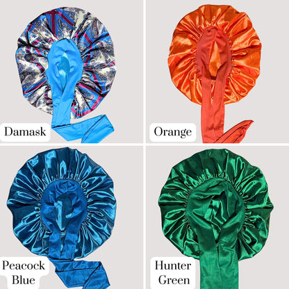 Four satin stretch-tie bonnets displayed in a grid showing Damask print with blue lining, bright orange satin, peacock blue satin, and hunter green satin from the Prince Hair Company Almost Perfect sample sale collection.