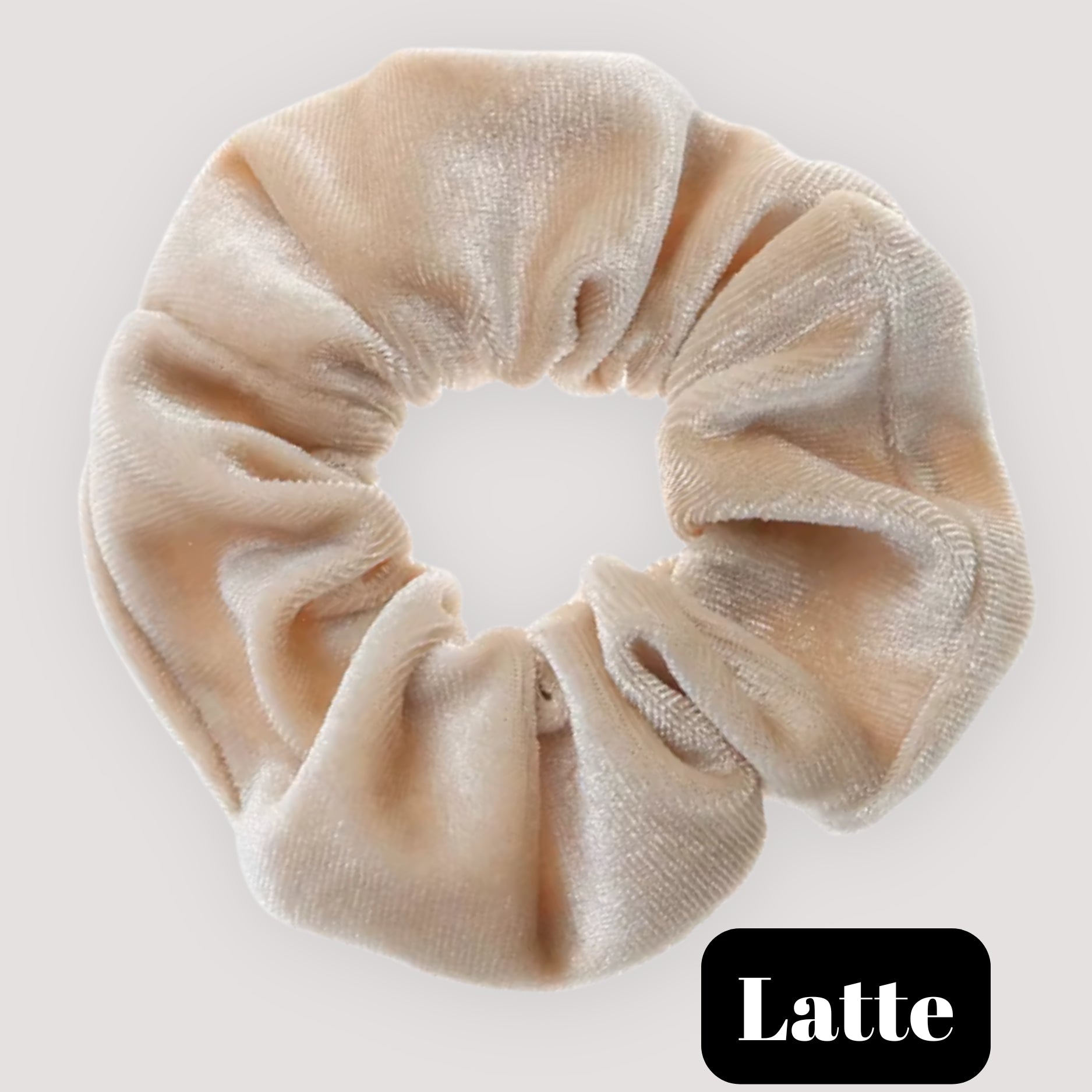 A single Latte beige handmade velvet scrunchie for damage-free hair styling on a light background, featuring a black label reading 'Latte'.