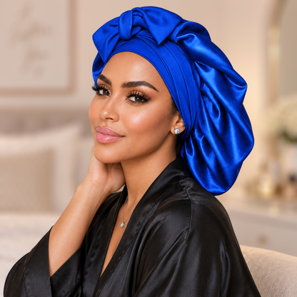 Large royal blue satin bonnet with matching bow, worn beside a vanity