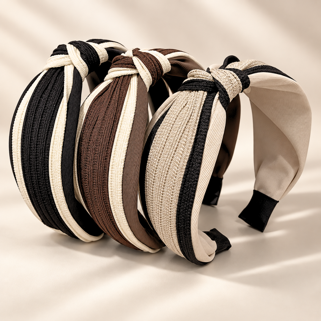 Three neutral twisted knot headbands displayed together in black and cream, brown and cream, and beige and black colorways.