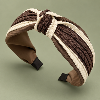 Brown and cream twisted knot headband at a three-quarter angle, showing its ribbed fabric and padded band.