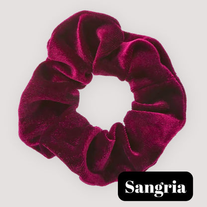 A single Sangria burgundy handmade velvet scrunchie for damage-free hair styling on a light background, featuring a black label reading 'Sangria