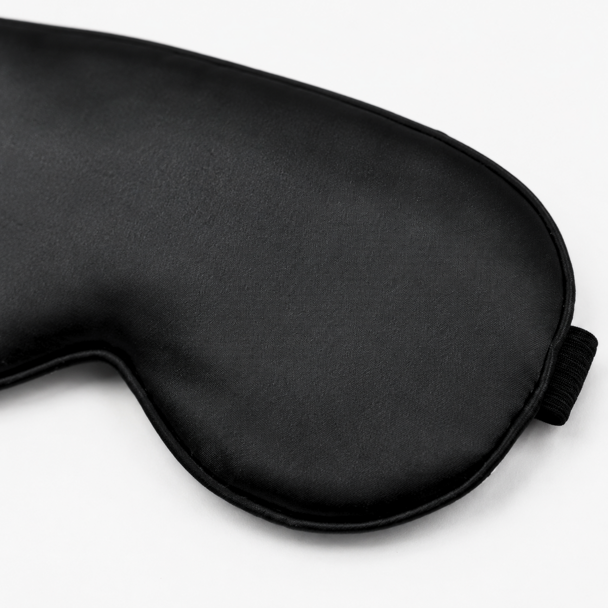 Close-up of black satin sleep mask fabric and piping