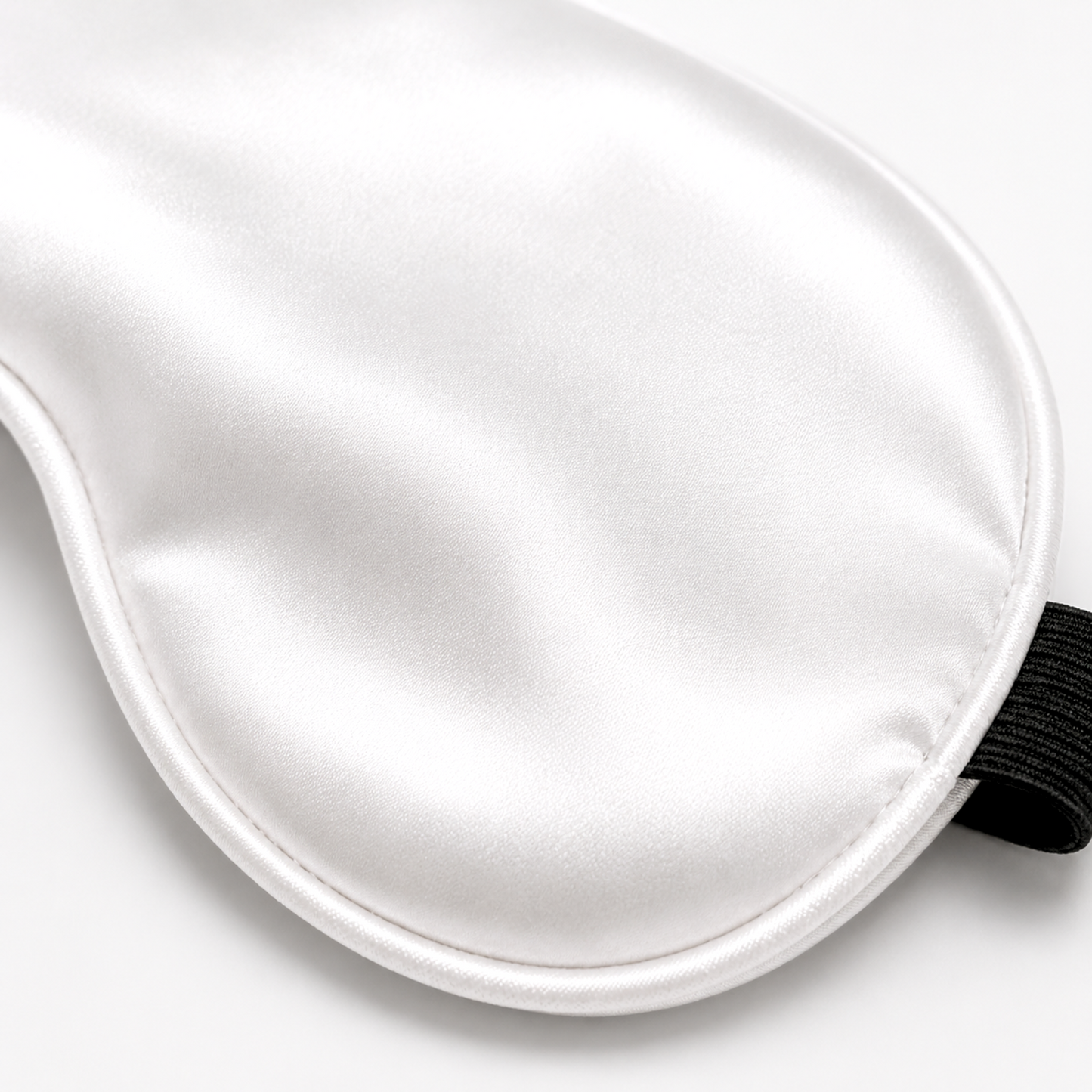 Close-up of white satin sleep mask fabric and piping
