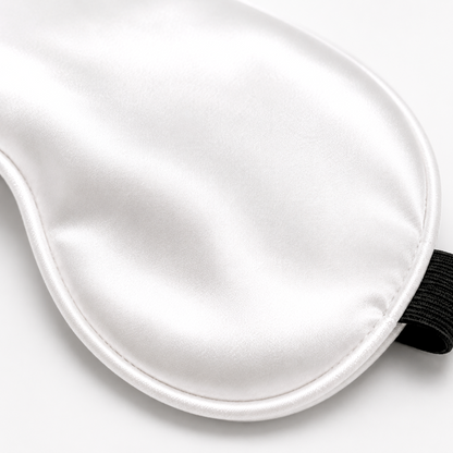 Close-up of white satin sleep mask fabric and piping