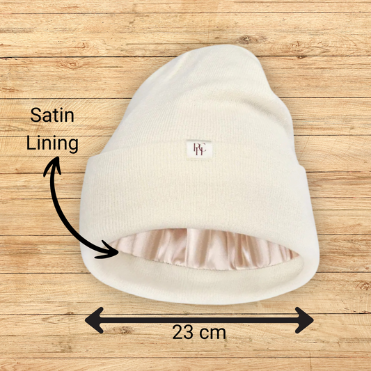 closeup picture of a Prince Hair Company PHC cream colored satin lined beanie with gold satin lining.