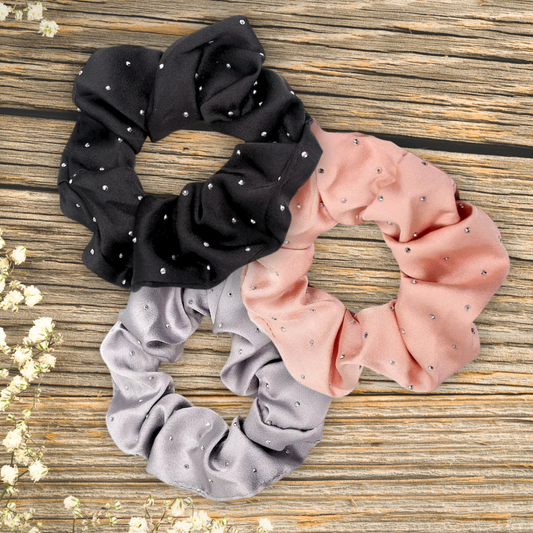 main image of black, rose gold and silver satin rhinestone scrunchies on a wood background