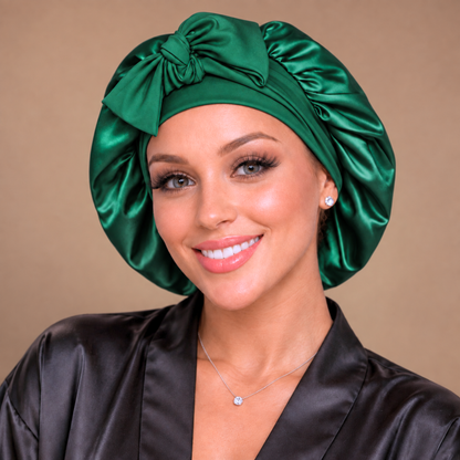 Front view of a small hunter green satin bonnet with matching bow
