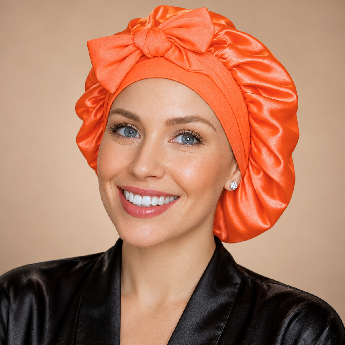 Small neon orange satin bonnet with matching bow, shown from the front