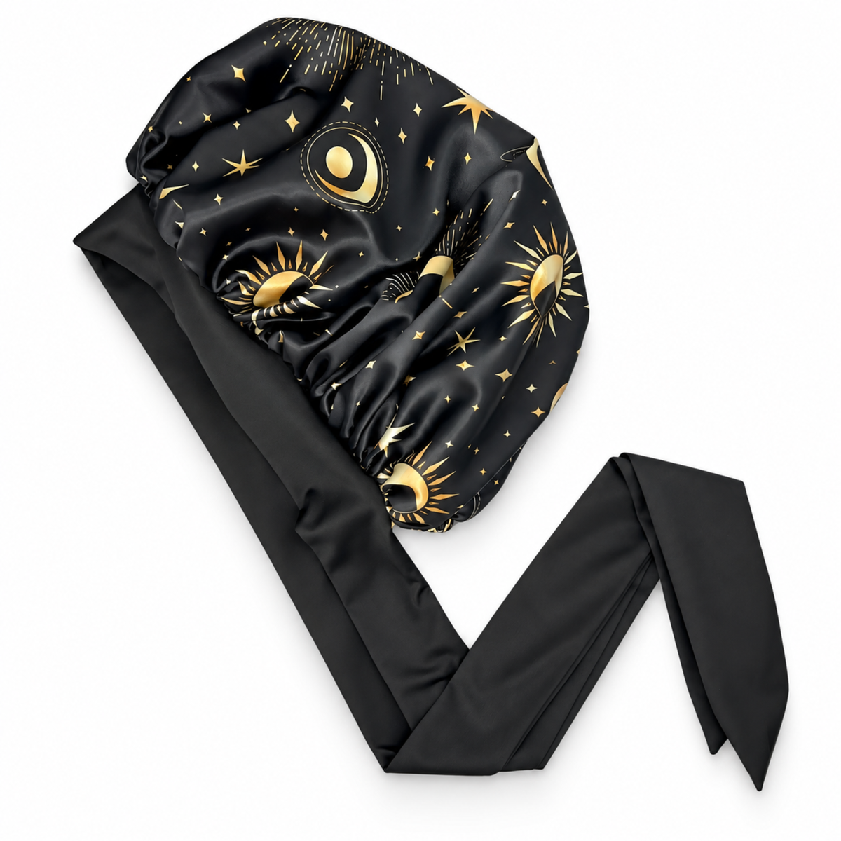 A black satin sleep cap with a long tie, decorated with a celestial pattern of gold suns, moons, and stars, shown on a plain white background.