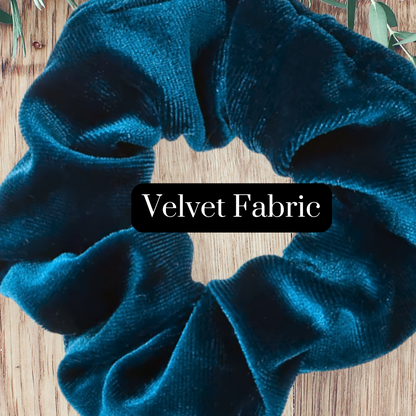 zoomed in details on a Prussian blue velvet scrunchie on a wooden background with the words "Velvet Fabric."