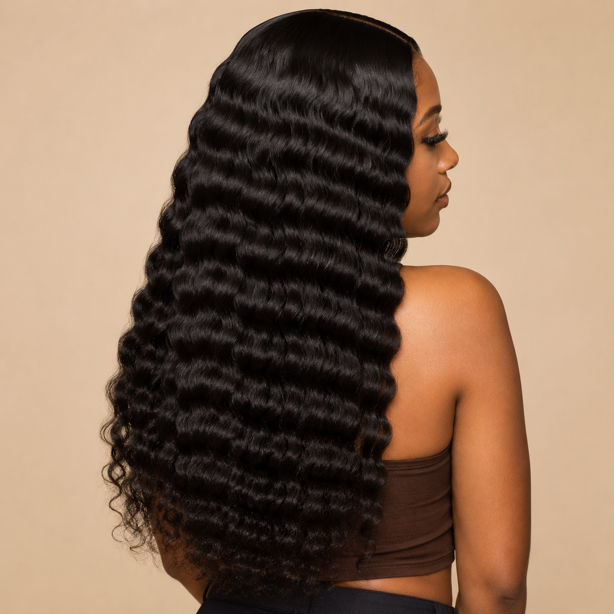 Model wearing natural black virgin Brazilian deep wave human hair bundles in a middle-part sew-in